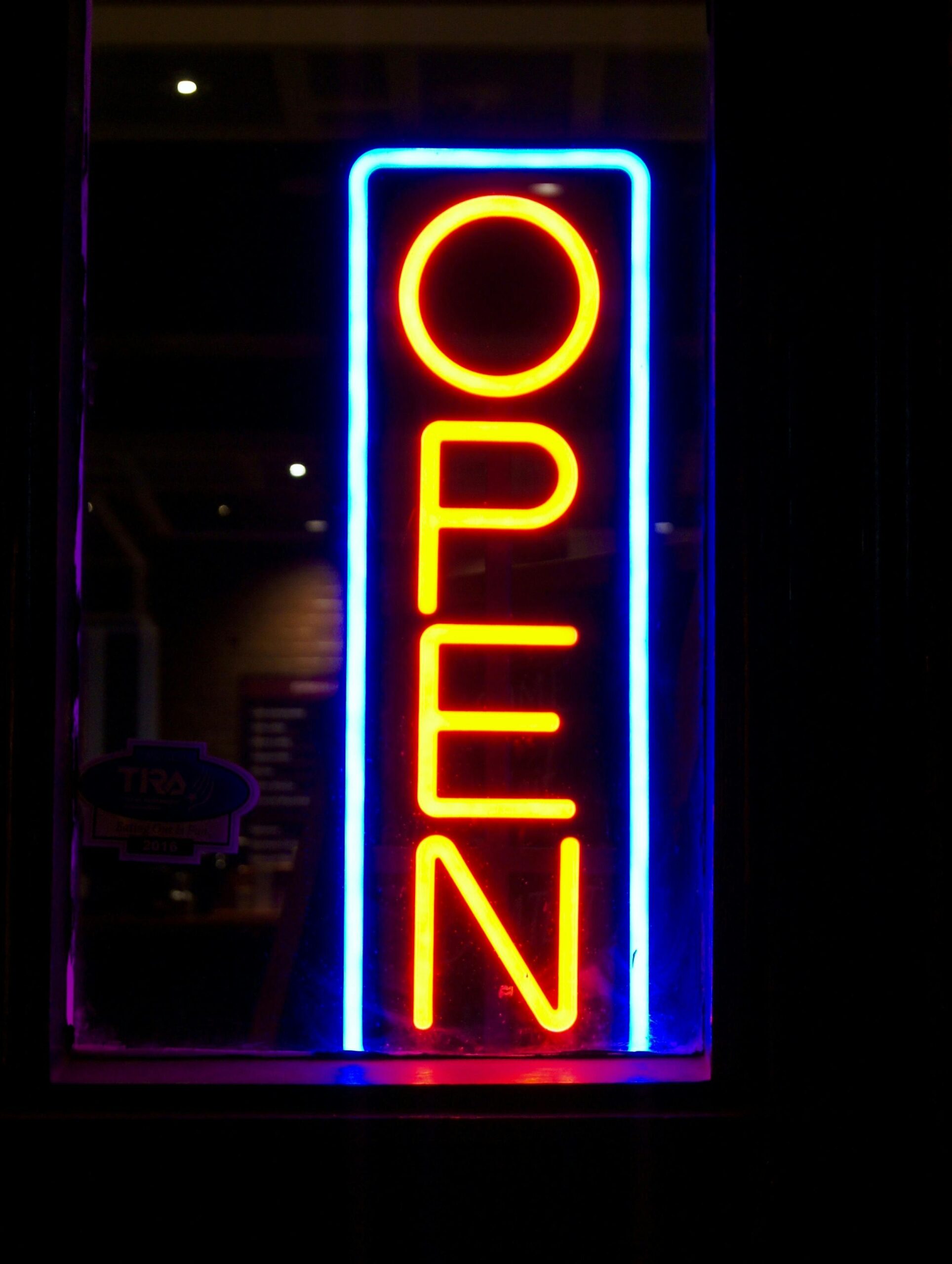 Illuminated neon sign displaying 'OPEN' with vibrant colors at night.